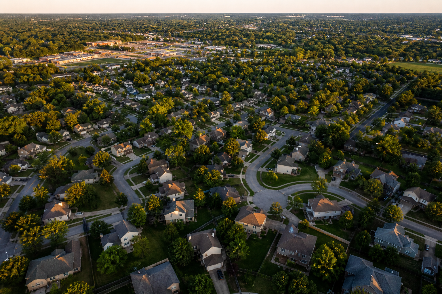 Aerial view of a leafy suburban Kansas neighborhood at golden hour